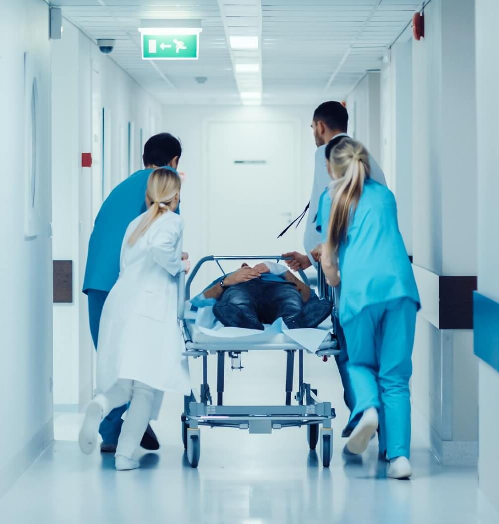 Acute Care Nurse Practitioners and Doctors Escorting a Patient on Gurnee